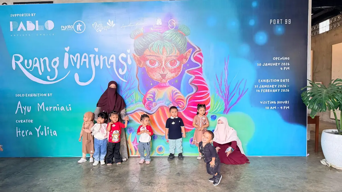 Berfoto di depan pameran karya.